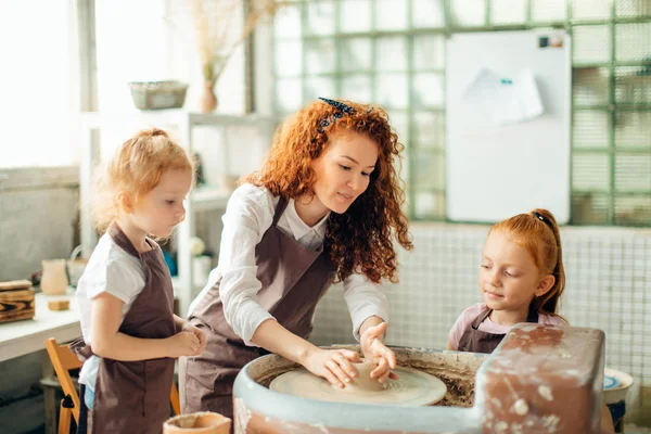 Mother and two redhead daughters made clay cup with pottery wheel — Stock Photo, Image