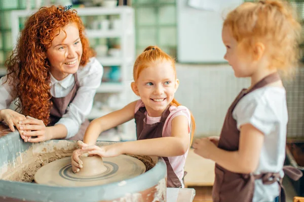 Мати і дві руді дочки зробили глиняну чашку з керамічним колесом — стокове фото