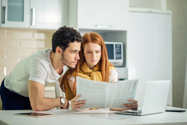 Familie beheer van de begroting, herziening van hun bankrekeningen met laptop in de keuken — Stockfoto