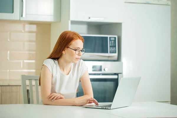 Parlak modern ofis içinde laptop üzerinde çalışan Kızıl saçlı işkadını konsantre — Stok fotoğraf