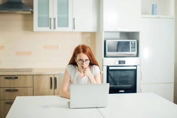 Female entrepreneur thinking while working at table in her kitchen at home — Stock Photo, Image