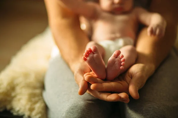 赤ちゃんにソフト フォーカスを持つ美しい手を母親の生まれたばかりの赤ちゃん足足します。 — ストック写真