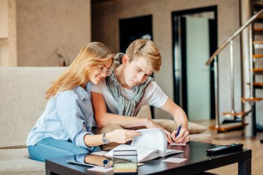 Çift öğrencilerin eğitim, kanepede otururken kitap okumak