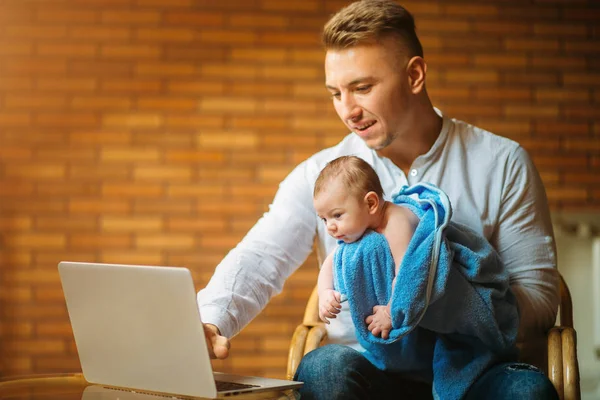 Ο πατέρας με το νεογέννητο μωρό που εργάζονται από το σπίτι χρησιμοποιώντας φορητό υπολογιστή — Φωτογραφία Αρχείου