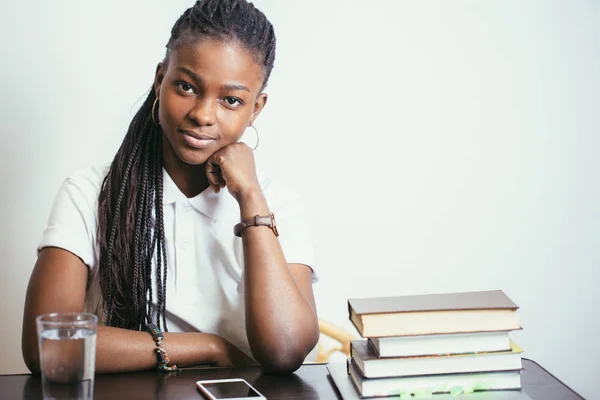 Evde kitap ile masada oturan Afrikalı genç bayan — Stok fotoğraf