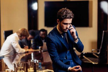 işadamı kameraya bulanık işçilerle arka plan üzerinde seyir.