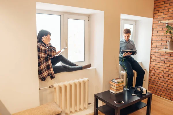 Man en vrouw rug aan rug zitten en doen hun werk — Stockfoto