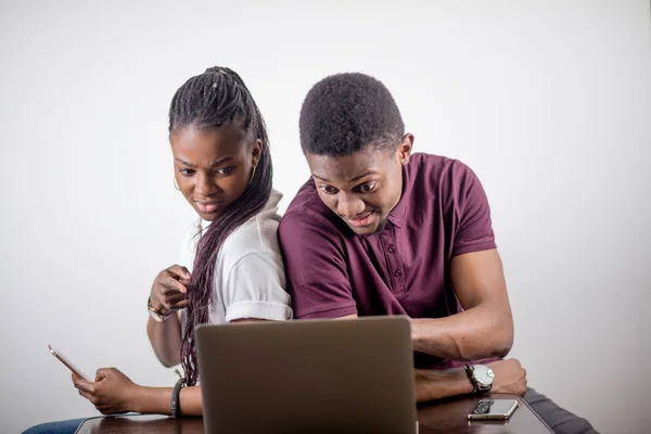 Schwarzes Mädchen sitzt vor dem Laptop und schaut auf den Bildschirm — Stockfoto