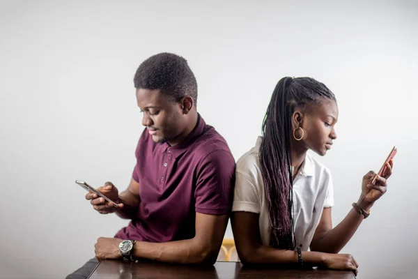 Afrykańska para trzymając telefonów komórkowych w rękę — Zdjęcie stockowe
