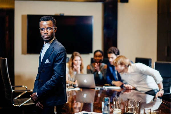 Afrikai üzletember keresi a kamera a háttérben üzletemberek csoportja — Stock Fotó