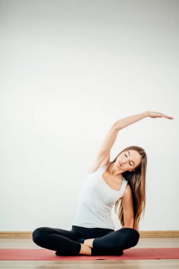 Aerobik egzersiz lotus poz mat oturan genç ince kız yapar