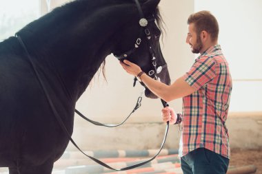 Genç adam atı ile. Sonbahar açık havada sahne
