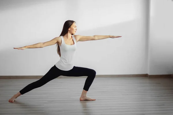 Yoga egzersiz yaparak çalışma beyaz tank top dışarı giyen genç kadın — Stok fotoğraf