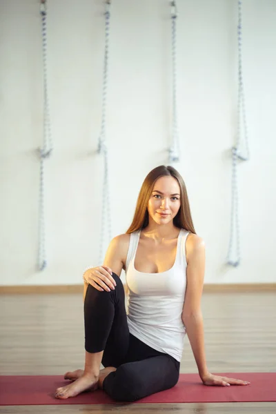 Caucasico ragazza seduta su mat e indossare abbigliamento casual — Foto Stock