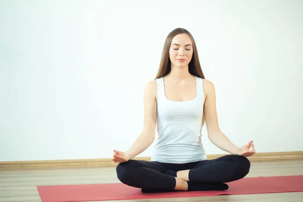 Mujer joven medita mientras practica yoga — Foto de Stock