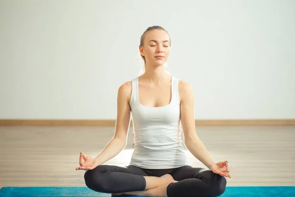 Mujer joven medita mientras practica yoga — Foto de Stock