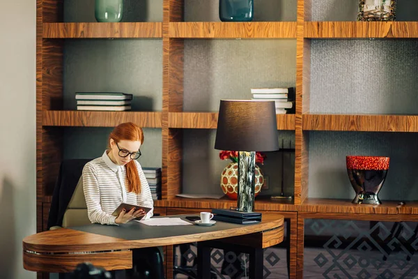 Affärskvinna som bär glasögon använder digitala tablett i office — Stockfoto