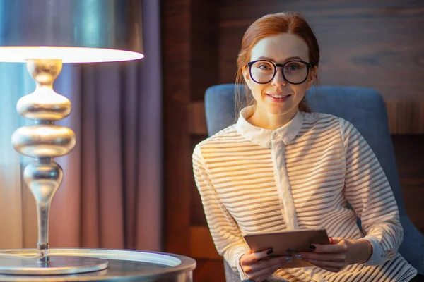 Hermosa mujer joven sosteniendo la tableta digital y mirando a la cámara con sonrisa — Foto de Stock