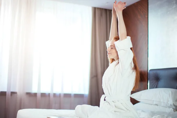 Κοκκινομάλλης γυναίκα απλώνεται στο κρεβάτι μετά το ξύπνημα — Φωτογραφία Αρχείου