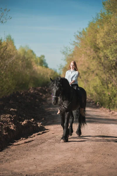 Brunette femme équitation sombre cheval à été vert forêt . — Photo