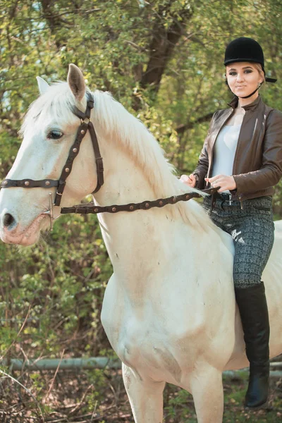 Morena mujer equitación oscuro caballo en verano verde bosque . —  Fotos de Stock