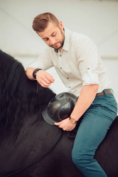 Hombre con camisa montada en un caballo marrón — Foto de Stock