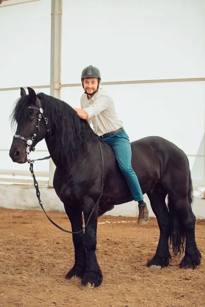 Hombre con camisa montada en un caballo marrón — Foto de Stock