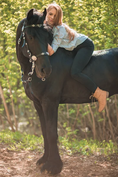 Молодая наездница с длинными волосами, лежащая на шее лошади — стоковое фото