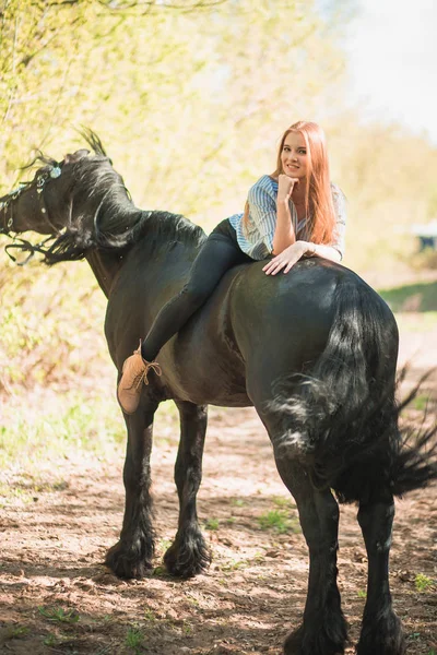 Jongere meisje met lang haar, liggend op de hals van het paard — Stockfoto