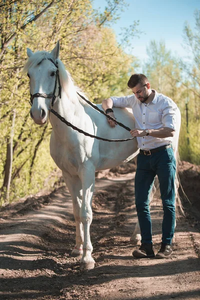 Young man with horse. Autumn outdoors scene — Stock Photo, Image