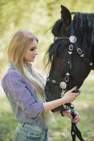 Lang haar jonge vrouw met een paard buiten — Stockfoto