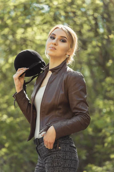 girl in riding clothes and helmet on a light background, the concept of jockey