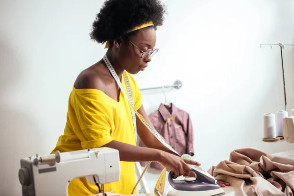 Afrikaanse vrouw naaister strijkdoek — Stockfoto