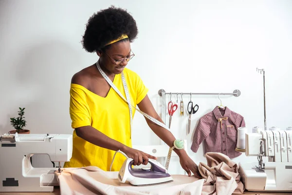 Afrikaanse vrouw naaister strijkdoek — Stockfoto