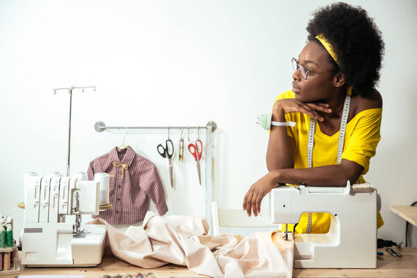 young woman seamstress thinking and working in studio