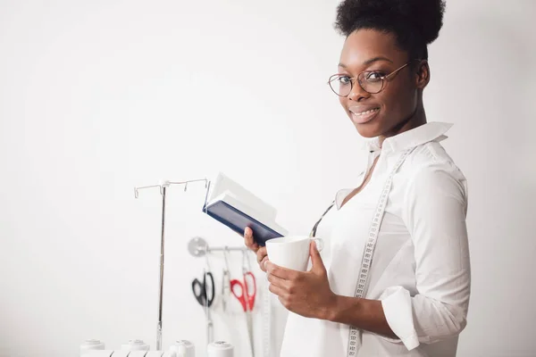 Lächelnde Näherin blickt mit Nähmaschine in die Kamera — Stockfoto