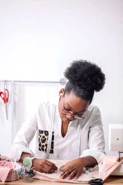 Costureira africana trabalhando com tecido toma medidas — Fotografia de Stock