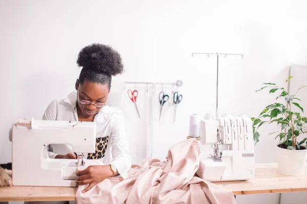 Costurera mujer sentado y cose en la máquina de coser. Dressmaker trabajando — Foto de Stock