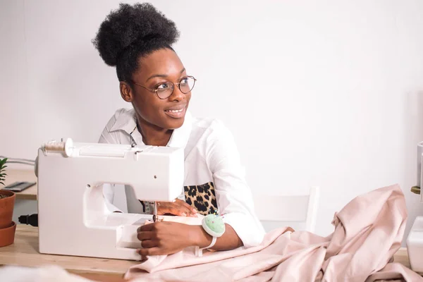 Femme couturière assise et coud sur machine à coudre. Dresseur de travail — Photo