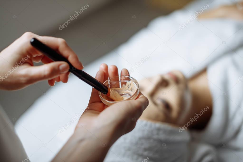 Young woman having mask procedure in spa centre