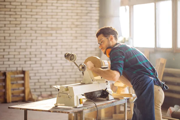 Aantrekkelijke man beginnen doen houtwerk in timmerwerk — Stockfoto