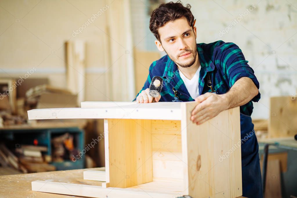 Carpenter hammering a nail into wooden board — Stock Photo