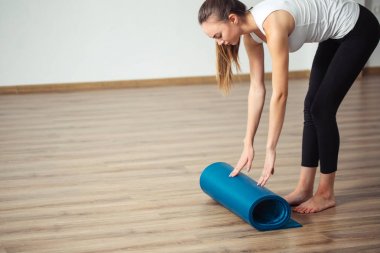 pratik yoga, uygulamada, unrolling veya çalışırken yoga mat hazırlama kadın