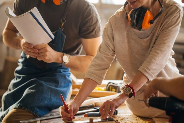 Carpintero entrenamiento hembra aprendiz a utilizar plano — Foto de Stock