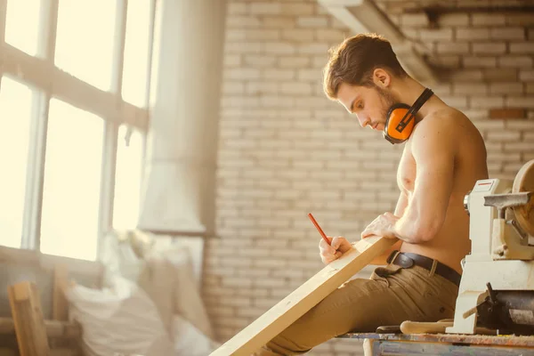 Carpenter using straightedge to draw line on board. — Stock Photo, Image