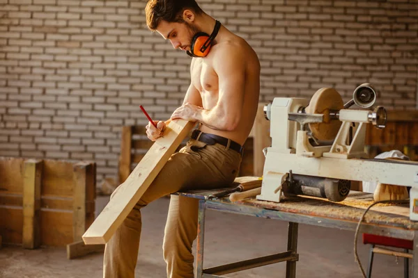 Carpenter using straightedge to draw line on board. — Stock Photo, Image