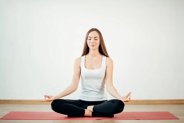 Mujer joven medita mientras practica yoga — Foto de Stock