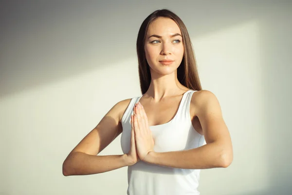 Frau praktiziert Yoga und Meditation, hält Handflächen in namaste mudra zusammen — Stockfoto