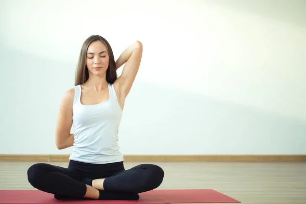 Bakifrån av fit kvinna gör gomukhasana i yogaklass — Stockfoto