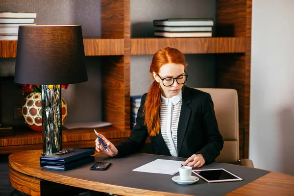 Mujer escribiendo en papel con tableta digital en la sala de oficina —  Fotos de Stock